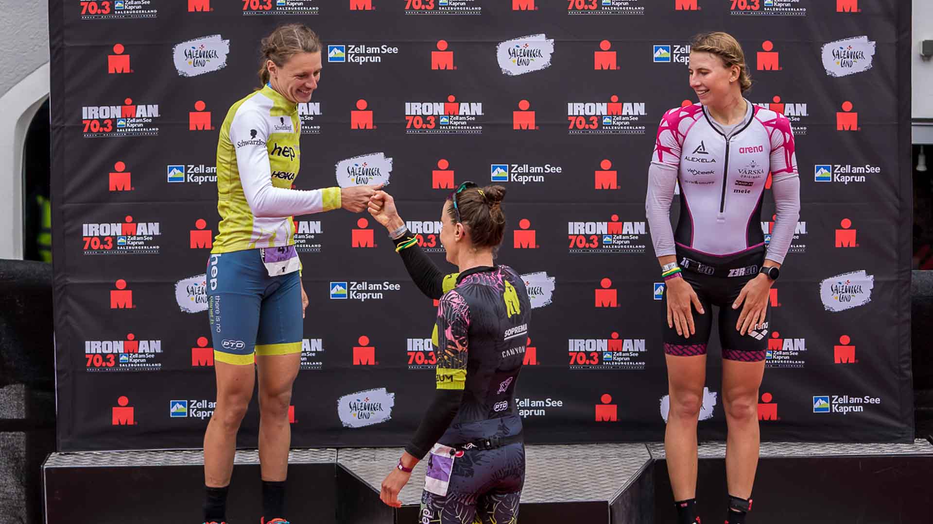 Anne Reischmann fistbumping a fellow female athlete at a prize ceremony